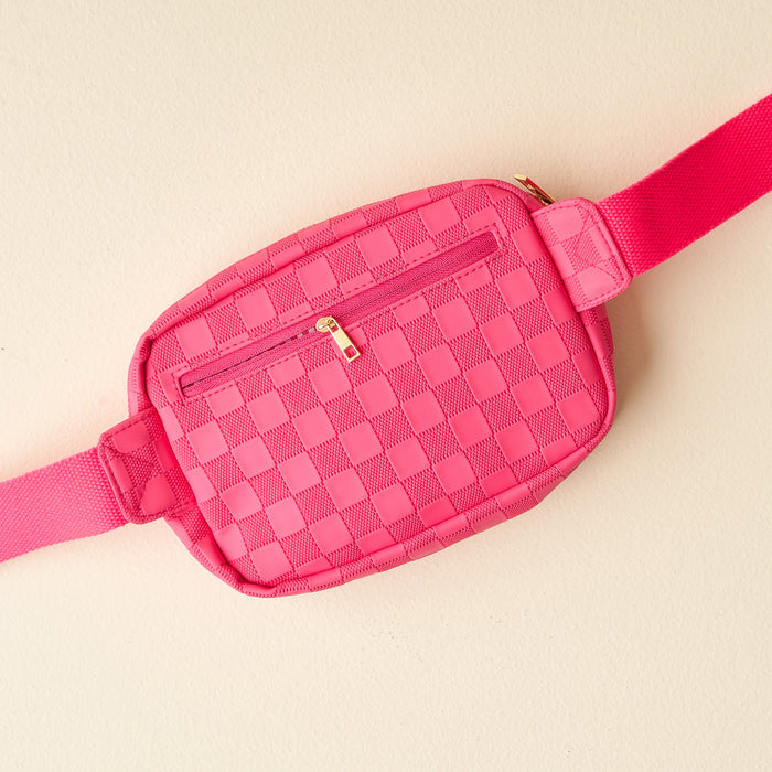 The Darling Effect’s Hot Pink Urban Check Belt Bag for women features a front zipper pocket and adjustable strap, crafted from vegan leather in a bold pink check pattern and displayed on a light beige background.