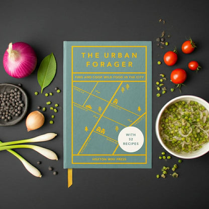 Forager Provisions LTD The Urban Forager hardback book surrounded by fresh vegetables and ingredients on a black table