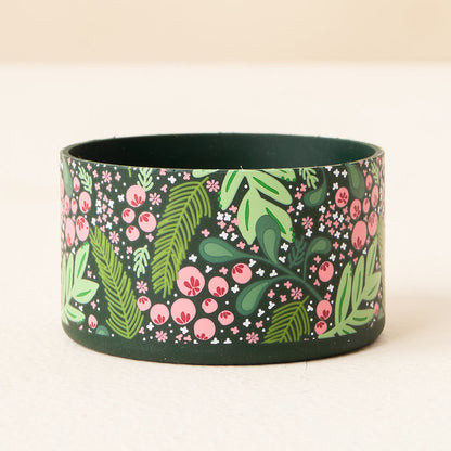 The Darling Effect Jolly Sprig Green Tumbler Silicone Boot features a dark green cylinder shape with a pink, green, and white floral pattern—perfect for protecting your tumbler.