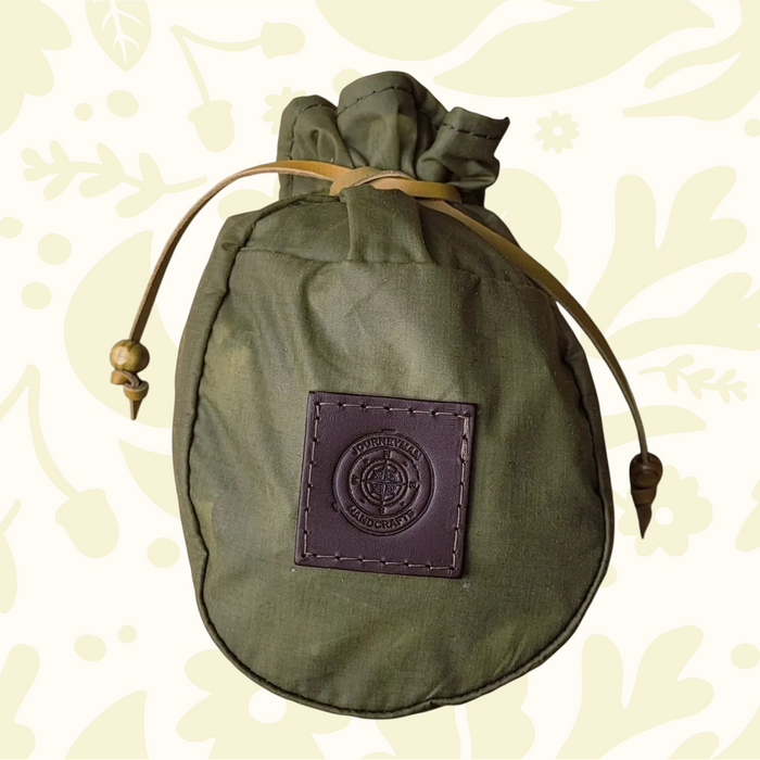 Journeyman Craft Khaki Green Waxed Canvas Coffee Pouch for camping, durable gear on a patterned background, eco-friendly.