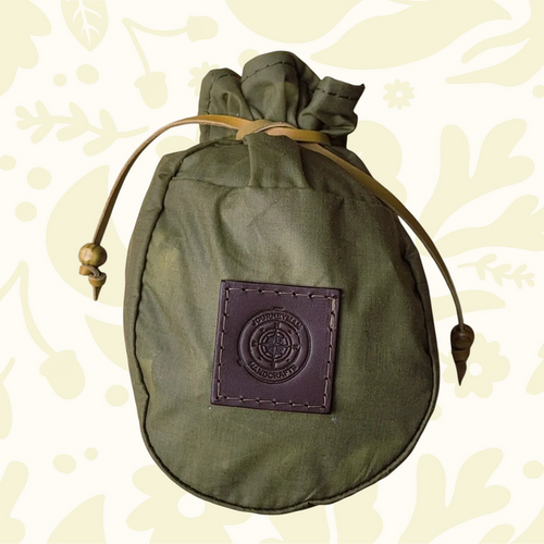 Journeyman Craft Khaki Green Waxed Canvas Coffee Pouch for camping, durable gear on a patterned background, eco-friendly.