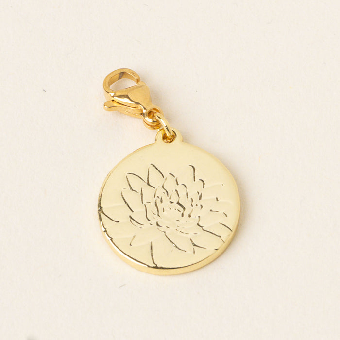 The July Jewelry Birth Flower Charm Gold by the-darling-effect features a gold round charm with a lobster clasp, delicately engraved with a lotus flower—an ideal accessory for birth flower jewelry lovers. Shown on a light, neutral background.