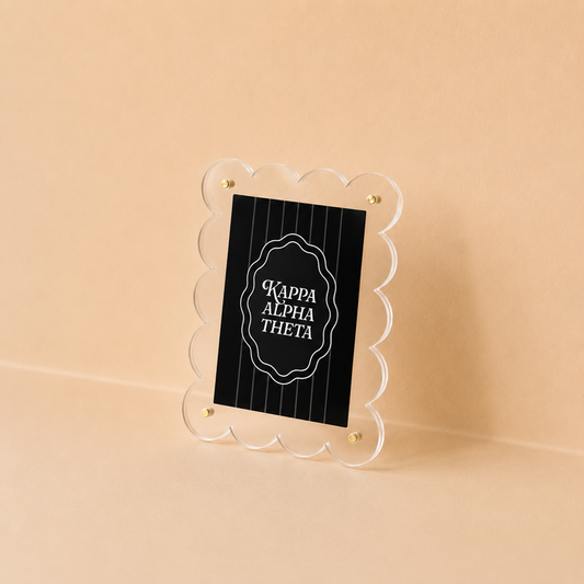 The Darling Effect's Kappa Alpha Theta Mini Acrylic Picture Frame Magnet features a scalloped-edge acrylic frame with a black sign, white accents, and elegant white lettering—perfect as a decorative mini magnet or picture frame for your space.