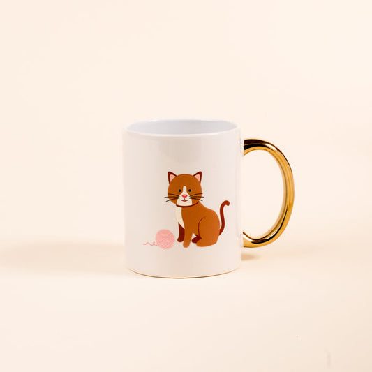 The Darling Effect's Kitty Corner 11 oz Cozy Cute Ceramic Mug features a cartoon brown cat with a ball of pink yarn and a golden handle—perfect for enjoying coffee or tea in adorable style.