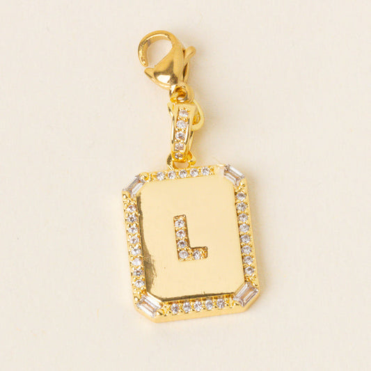 The-darling-effect’s L Jewelry Charm Initial Letter Gold features a gold rectangular pendant with a bold L, sparkling stone border, and lobster clasp—perfect for anyone who loves personalized initial jewelry.