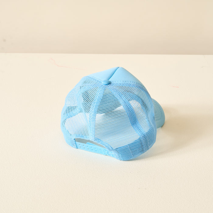 The Darling Effect Light Blue Game Day Trucker Hat is shown upside down on a white surface, with its adjustable strap and mesh back facing the camera, standing out against a neutral background.