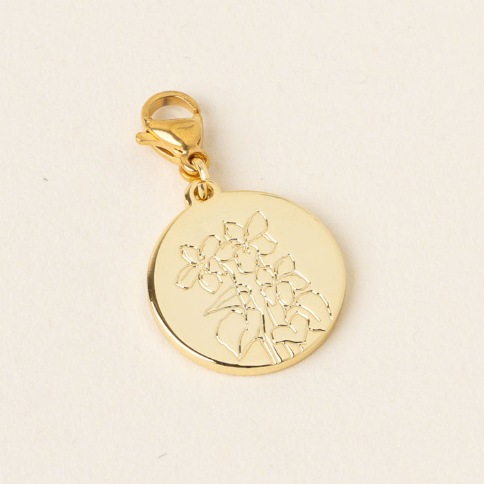 The March Jewelry Birth Flower Charm Gold by the-darling-effect is a round gold pendant with an engraved floral design and a lobster clasp, photographed against a plain light background.