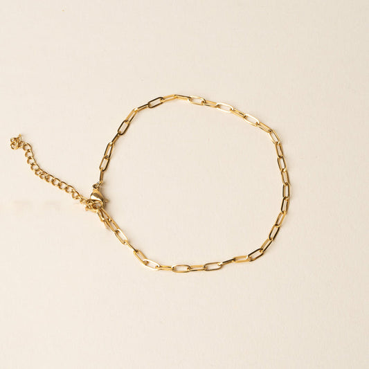 The Mia Paper Clip Chain Bracelet by the-darling-effect features elongated oval links and an adjustable clasp, offering a stylish accent to your look. Shown against a light beige background, it's a chic addition to any jewelry collection.