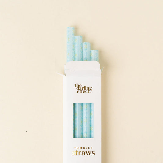 A white box labeled "the-darling-effect" holds five light blue, BPA-free Oh So Fancy Blue 40 oz Tumbler Straws with a subtle pattern, partially sticking out against a cream background.