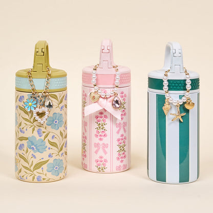 The Darling Effect's Book Shelfie 6 oz Lil' Bitty Bottle features floral designs, pink and green stripes—perfect as a stylish travel companion.