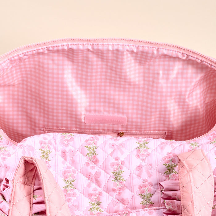 A close-up of the Oh So Fancy Pink On-the-Go Quilted Weekender Bag by The Darling Effect shows its pink and white gingham lining and a zippered pocket—ideal for keeping essentials organized on your next trip.