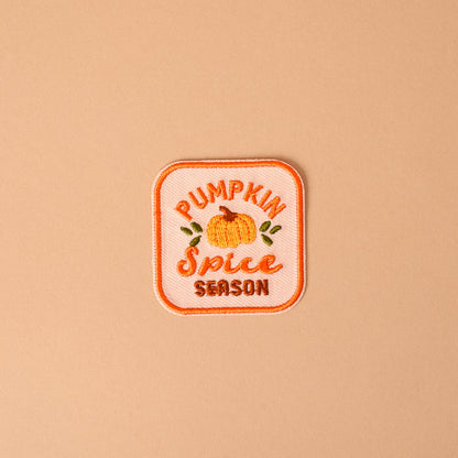 Bring a cozy autumn vibe to your favorite jacket or bag with The Darling Effect’s On Patch-Pumpkin Spice Season Mix & Match Iron! This embroidered patch features a charming pumpkin illustration along with the words “Pumpkin Spice Season” in vibrant orange and yellow on a light peach background—perfect for customizing your look and adding seasonal flair with colorful, iron-on designs.