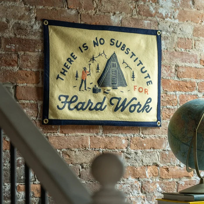 Oxford Pennant camp flag with “There Is No Substitute For Hard Work” text, cabin, and pine trees outdoors illustration.