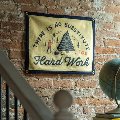 Oxford Pennant camp flag with “There Is No Substitute For Hard Work” text, cabin, and pine trees outdoors illustration.