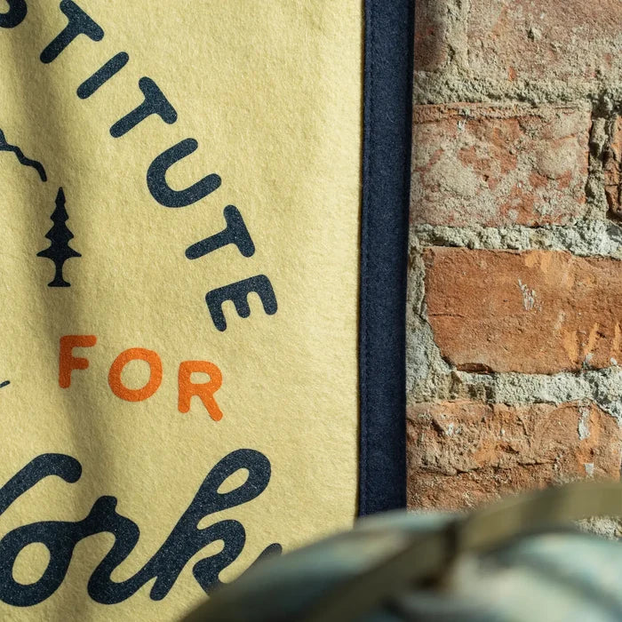 Oxford Pennant “There Is No Substitute For Hard Work” flag as wall décor on brick, motivational banner for workspace.
