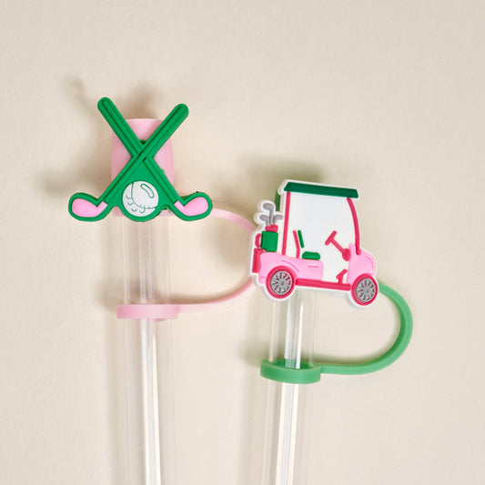 The Darling Effect’s Par-tee Pack Straw Topper Set includes two clear plastic straws with leak-resistant silicone toppers: one with crossed green golf clubs and a ball, and the other with a pink and white golf cart—perfect for fun drinkware accessories.