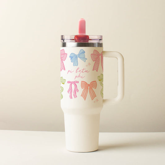 The Darling Effect's Pi Beta Phi 40 oz Lifestyle Flip Straw Tumbler Bow Affair features a white design with pastel bows, “pi beta phi” text, a handle, a clear leak-resistant lid, and a pink straw against a plain light background.