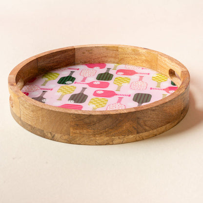 The-darling-effect’s Pickleball Party Large Round Wood Enamel Tray features handles and a vibrant pink, green, and white bottle pattern—perfect for adding playful style to any gathering.