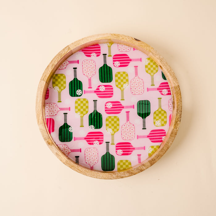 The Pickleball Party Large Round Wood Enamel Tray by the-darling-effect features a vibrant green and pink pickleball paddle and ball pattern on white—perfect for fun gatherings and entertaining.