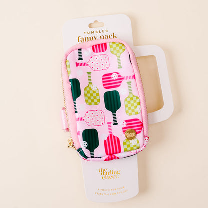 The Pickleball Party Tumbler Fanny Pack by the-darling-effect is a small, pink, zippered pouch with colorful paddle patterns, shown on white packaging. It’s water resistant and displayed against a light beige background.