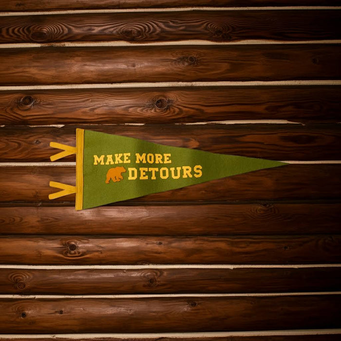 Forager Provisions LTD wool felt pennant in olive green with Make More Detours text and bear icon on wood wall