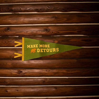 Forager Provisions LTD wool felt pennant in olive green with Make More Detours text and bear icon on wood wall