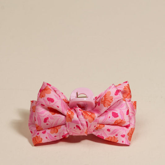 The Darling Effect's Poppin' Petals Hot Pink Mini Satin Bow Claw Clip is a cute pink floral hair accessory, featuring a satin bow for an elegant touch to any hairstyle.