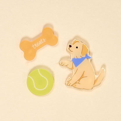 The Darling Effect’s Puppy Playtime Little Magnet Set features a yellow puppy in a blue bandana, sitting with a green tennis ball and orange bone-shaped treat—adorable decorative accents or fridge magnets for any light background.