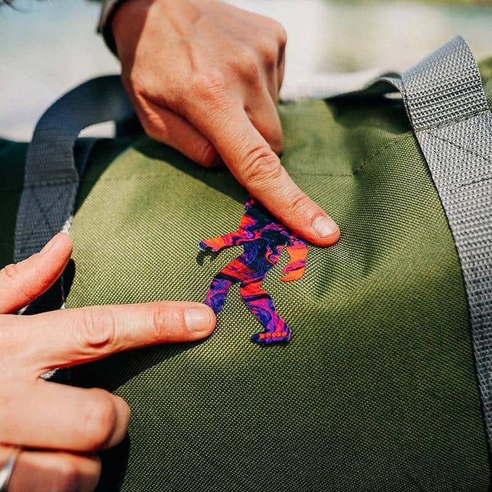 Forager Provisions LTD NoSo repair patch featuring a psychedelic tie-dye Sasquatch design applied to a green backpack.