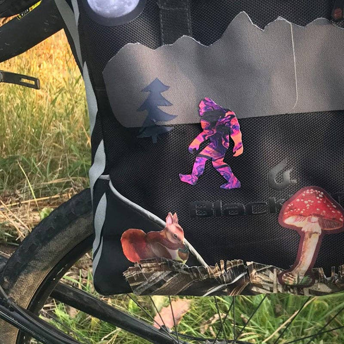 Forager Provisions LTD NoSo psychedelic tie-dye Sasquatch repair patch applied to a black outdoor backpack