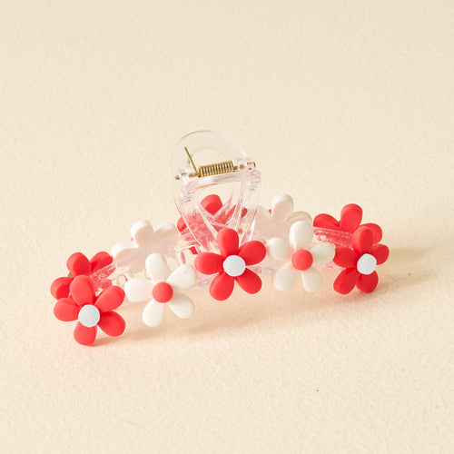 The Darling Effect’s Red Game Day Daisy Claw Clip features red and white daisy-shaped flowers—ideal for sporting your school colors or elevating your Game Day style, displayed on a light beige surface.