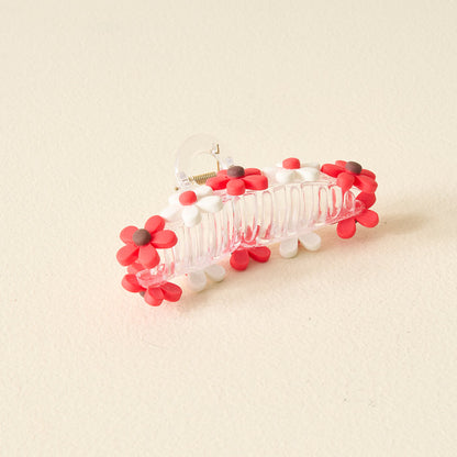 The Darling Effect's Red Game Day Daisy Claw Clip features red and white daisy-shaped charms with brown centers—a fun, spirited accessory to show off your school colors on Game Day.