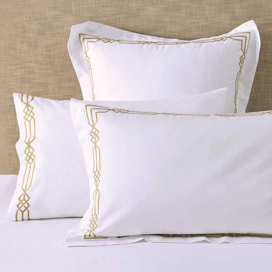 Renata Gold Pillowcase on a beige textured wall background