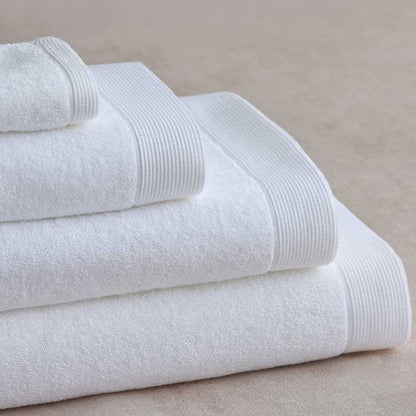 Stack of Renew Towel White on a beige surface