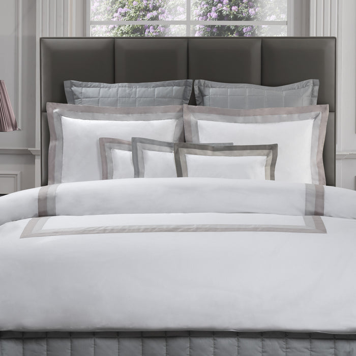 Neatly made bed with Samuele pillowcase sham and duvet cover in a bedroom setting.