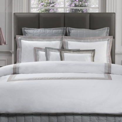 Neatly made bed with Samuele pillowcase sham and duvet cover in a bedroom setting.