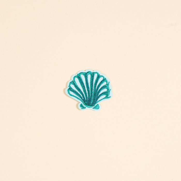 The Darling Effect’s Seashell Mix & Match Iron-On Patch features teal embroidered scallop shell details on a pale peach background—ideal for adding colorful flair to your jackets and accessories.