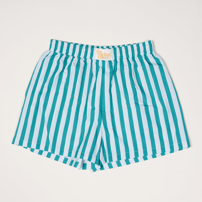 The Darling Effect Sicily Stripes Teal All Day Boxer Shorts feature vertical teal and light blue stripes, breathable fabric, an elastic waistband, and a white label with orange text. They're laid flat on a white background for a trendy look.