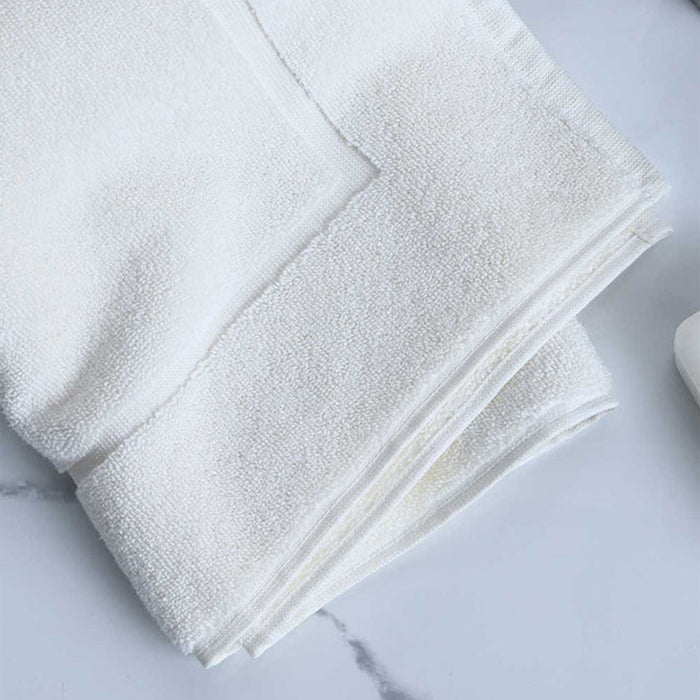 Folded Signature Bath Mat Ivory on a marble surface