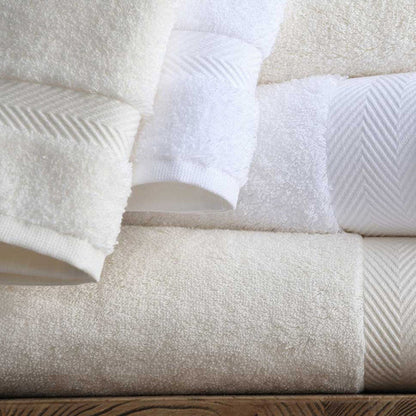 Stack of Signature Towels White and Ivory on a wooden surface