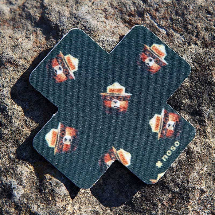 Forager Provisions LTD Smokey Bear Head Toss x NoSo repair patch on a textured rock surface.