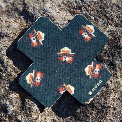 Forager Provisions LTD Smokey Bear Head Toss x NoSo repair patch on a textured rock surface.
