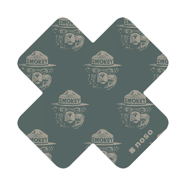 Forager Provisions LTD Smokey Bear woodblock cross repair patch in dark green with a repeating bear face pattern.