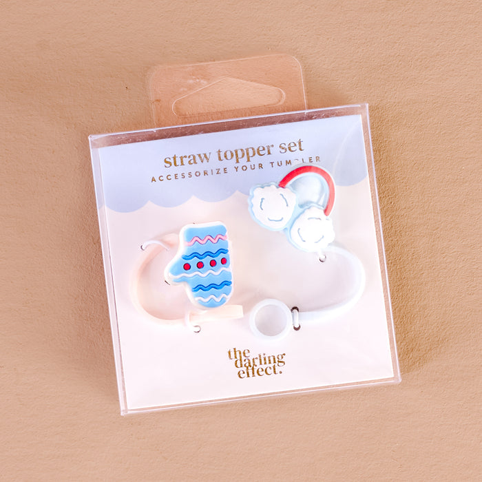 The Darling Effect's Snow Much Fun Straw Topper Set includes colorful silicone toppers—a mitten, rainbow, and white ring—fun drinkware accessories packaged with “straw topper set” and brand name on a light brown background.