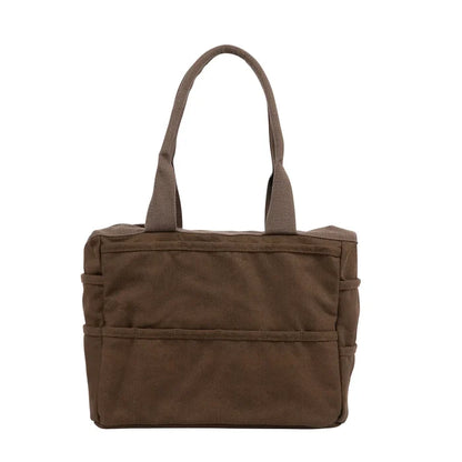 Soolla Studio Pottery Artist Bag in Coffee Bean brown canvas, sturdy handles, spacious pockets, on crisp white background.