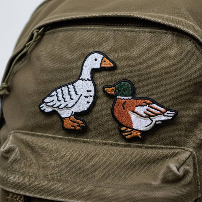 Forager Provisions LTD Stay Home Club sticky patches featuring illustrated goose and mallard duck on an olive backpack