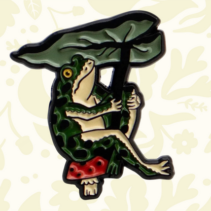 Forager Provisions LTD enamel pin featuring a green frog sitting on a mushroom under a large leaf umbrella