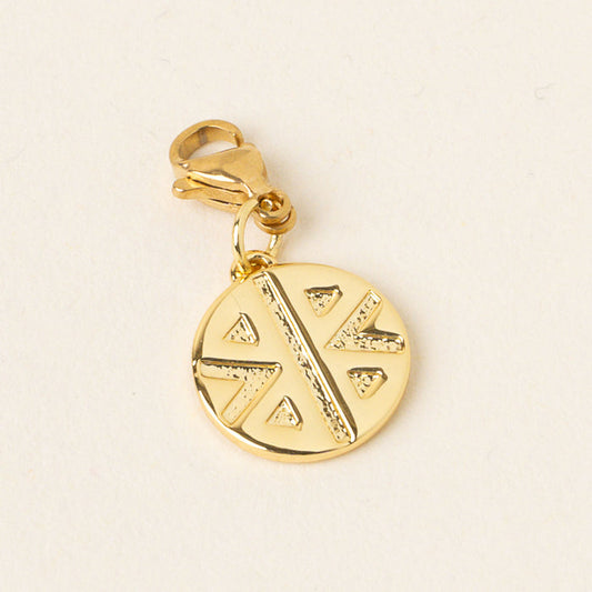 The Strong Jewelry Trait Charm Gold by the-darling-effect features a circular gold pendant with a raised geometric pattern and clasp, part of the Jewelry Trait Charms collection.