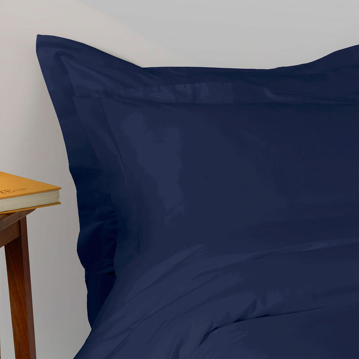 Suave-Midnight pillowcase and duvet cover and bedding set with a wooden side table and book in the background.