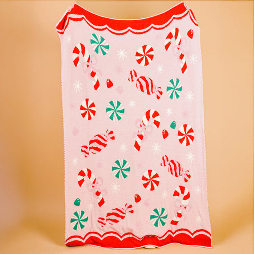 The Darling Effect's Sugar Rush Cozy Dreams Luxe Blanket features candy cane, peppermint, and wrapped candy patterns with a red scalloped edge—an ultra-soft, stylish blanket perfect for cozy snuggles.